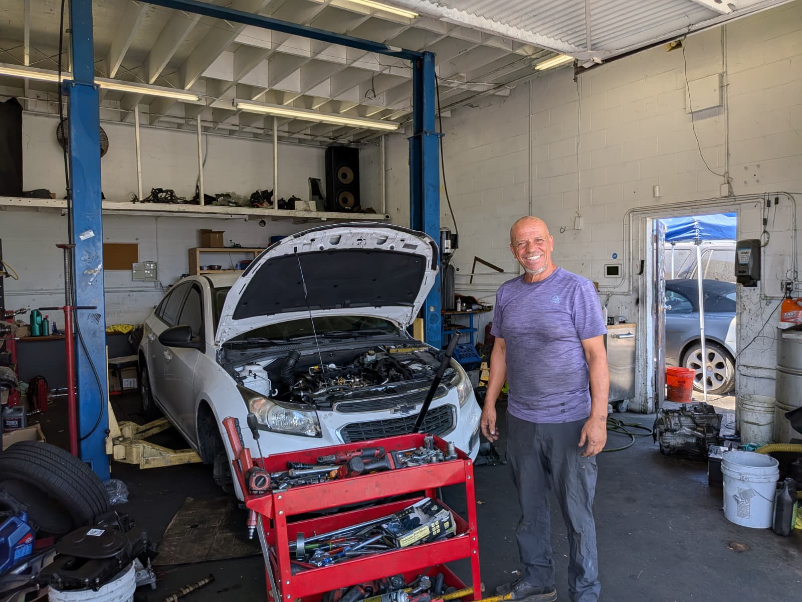Engine Bros mechanic working on a car engine in the shop