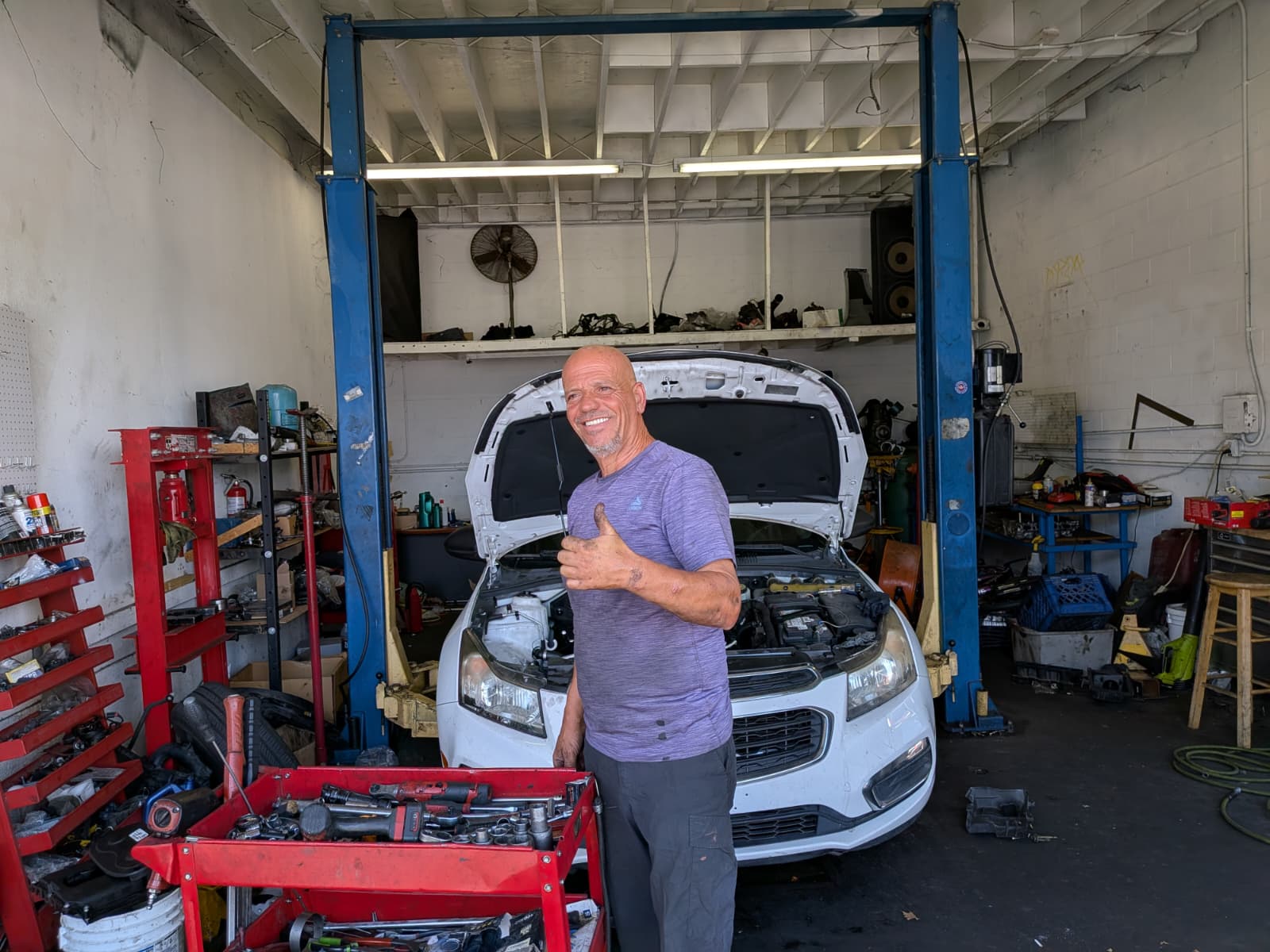The owner of Engine Bros Auto Repair smiling in the shop